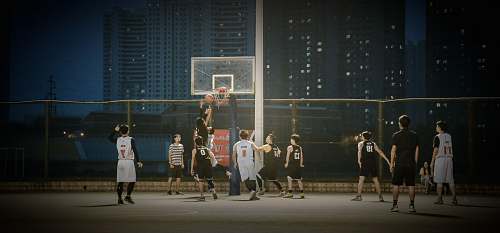 human group of men playing basketball during nighttime music